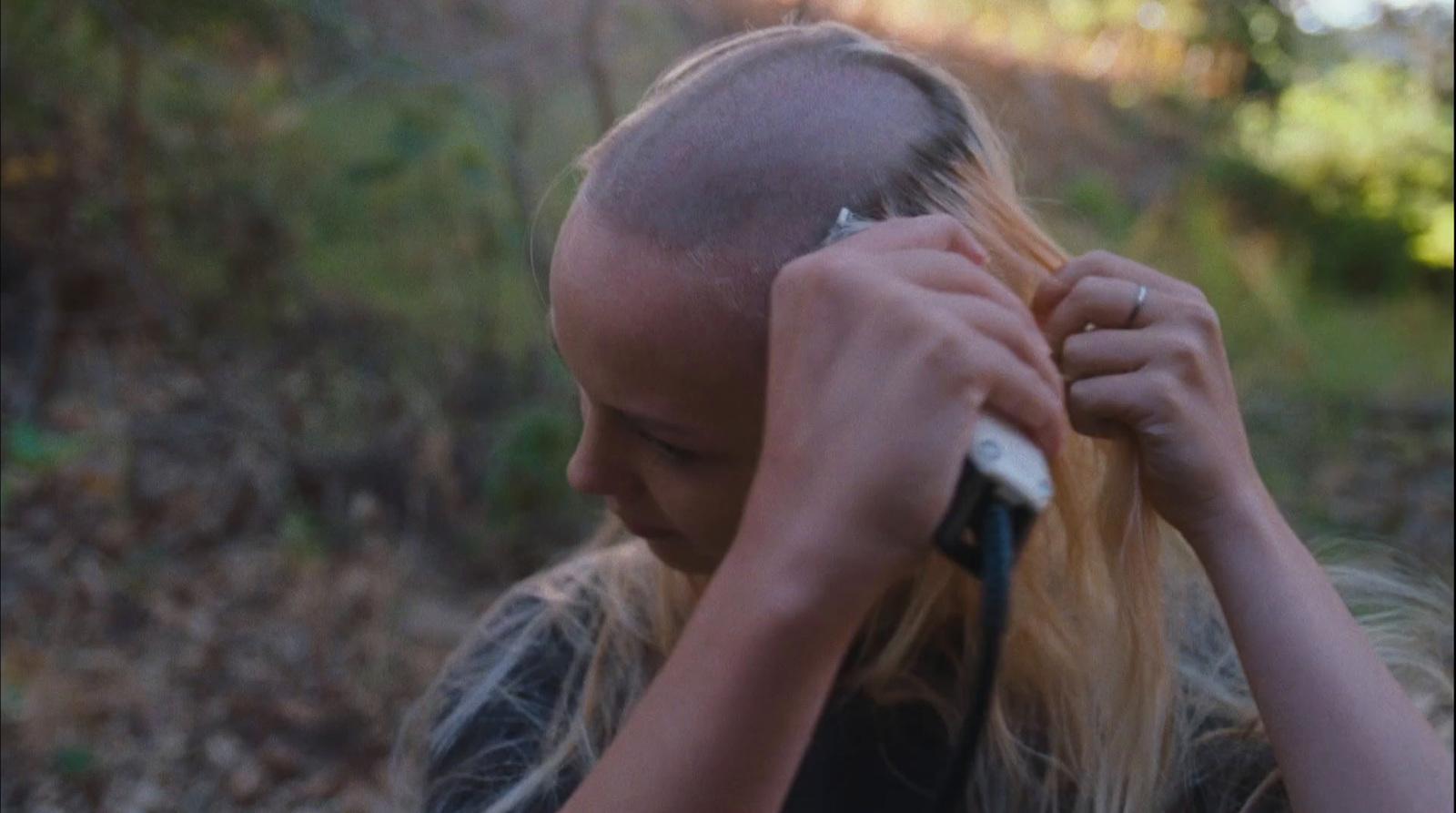 a woman combing her hair in the woods