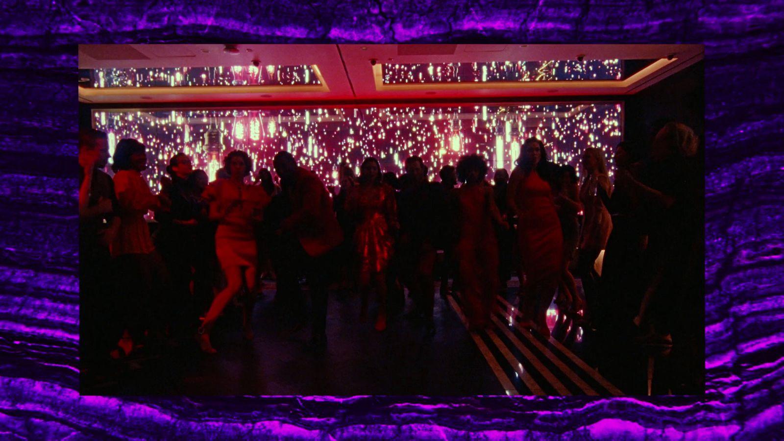 a group of people standing in front of a purple wall