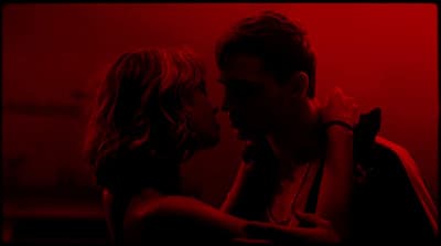 a man and a woman kissing in a dark room