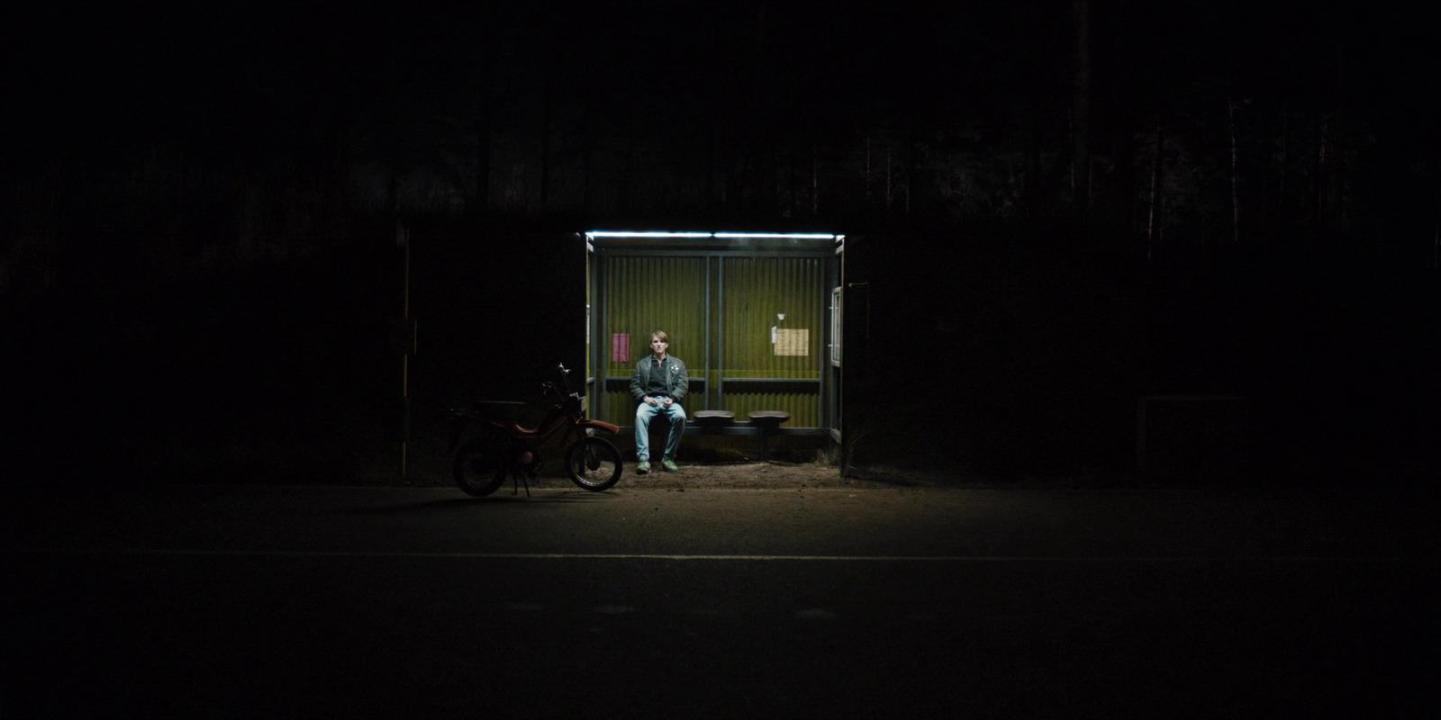 a man sitting on a bench in the dark