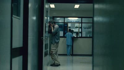 a man standing in a hallway talking on a cell phone