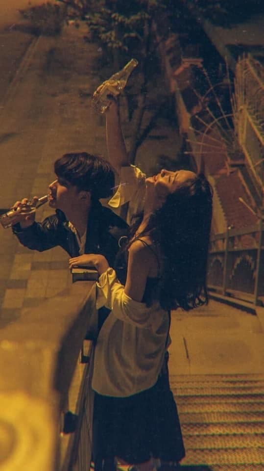 a man and a woman leaning against a railing