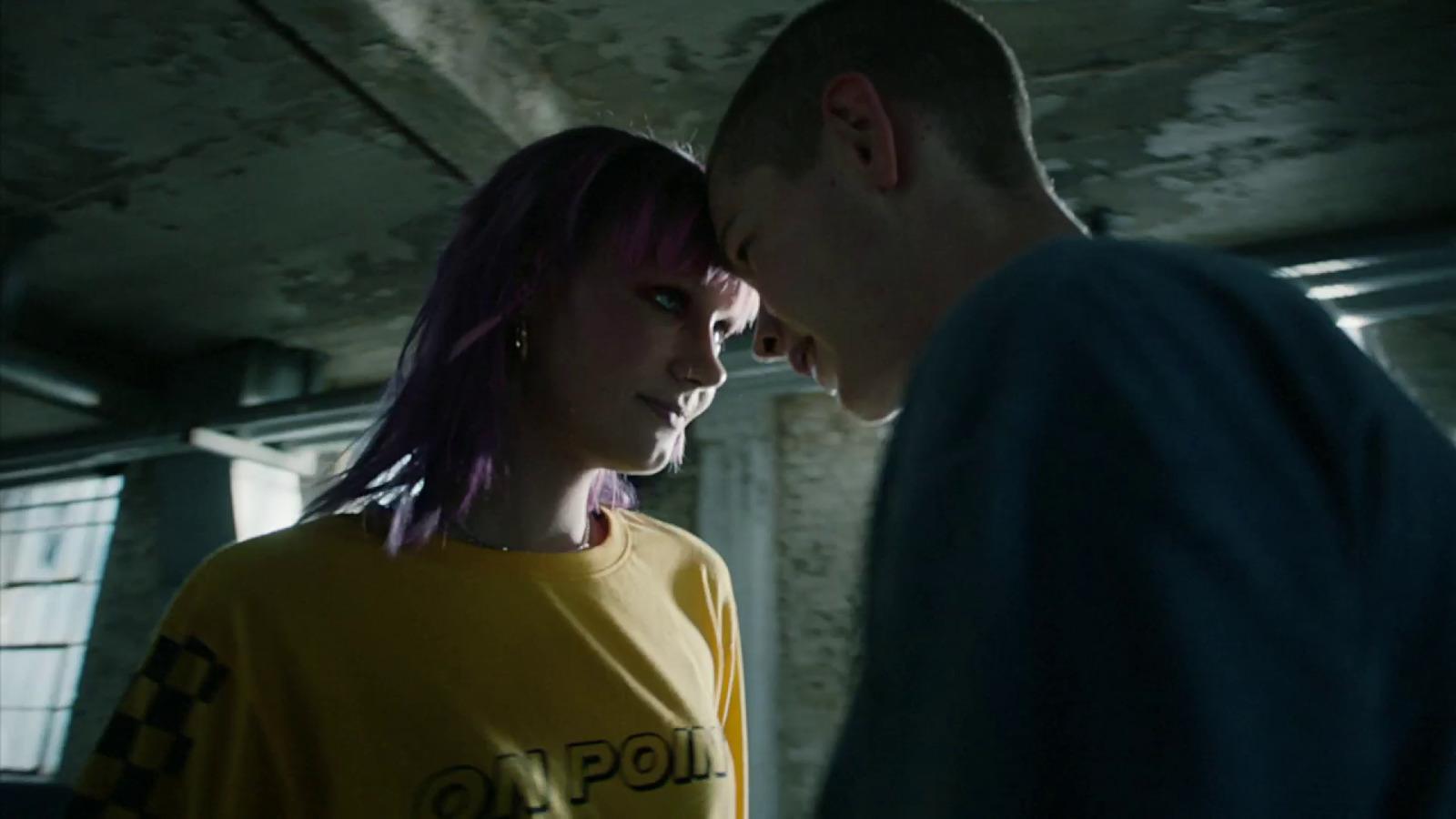 a man standing next to a woman in a yellow shirt