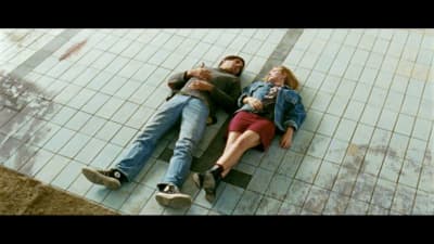 a man and a woman laying on a tiled floor