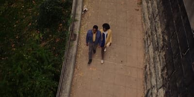 a couple of people walking down a sidewalk
