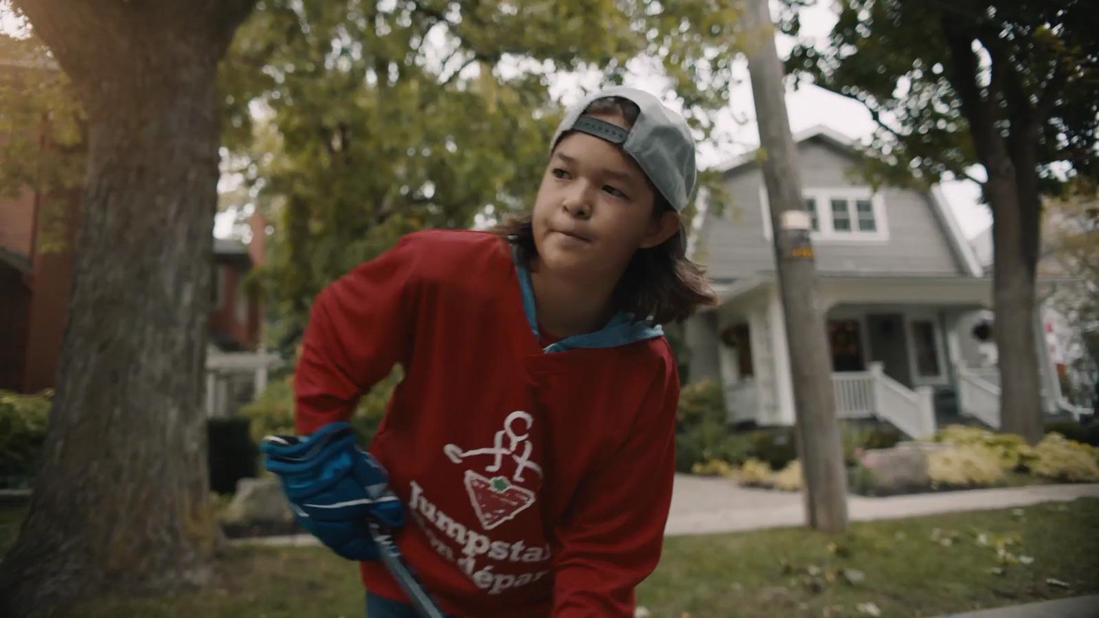 a girl in a red shirt is holding a baseball bat