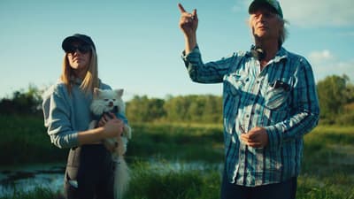 a man and a woman holding a small dog