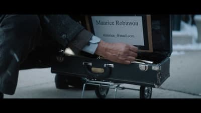 a man is pulling a suit case with a sign on it