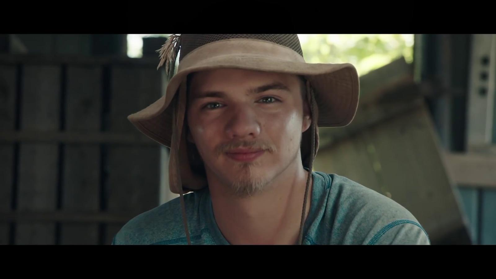 a man wearing a hat and a green shirt