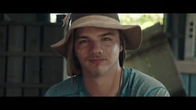 a man wearing a hat and a green shirt