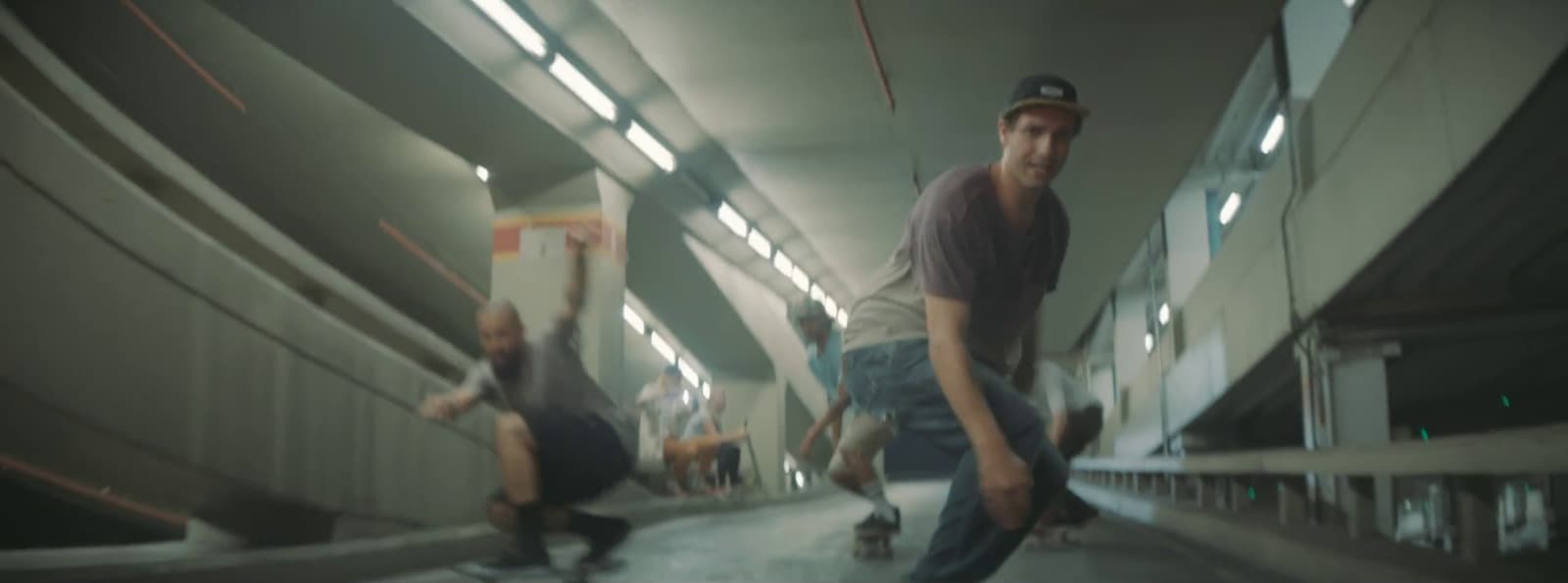 a group of men riding skateboards down a hallway