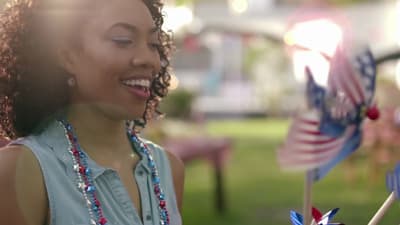 a woman standing next to a flag pinwheel