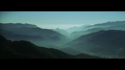 a view of a valley with mountains in the background