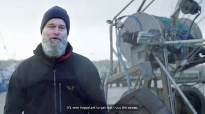 a man with a beard standing next to a boat
