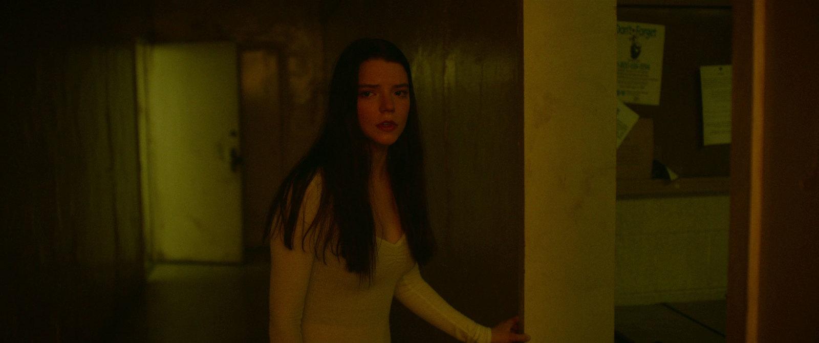 a woman standing in a room with a knife in her hand