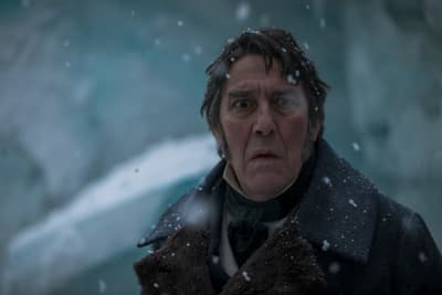 a man in a coat is standing in the snow
