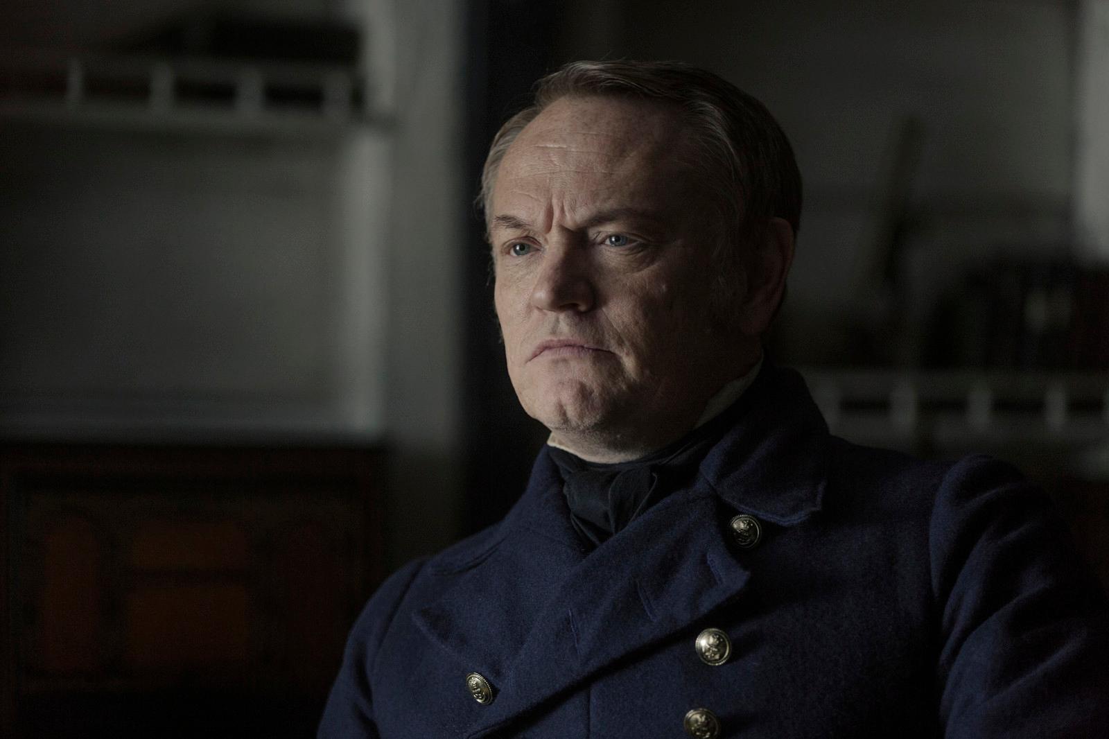 a man in a pea coat looking at the camera