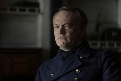 a man in a pea coat looking at the camera