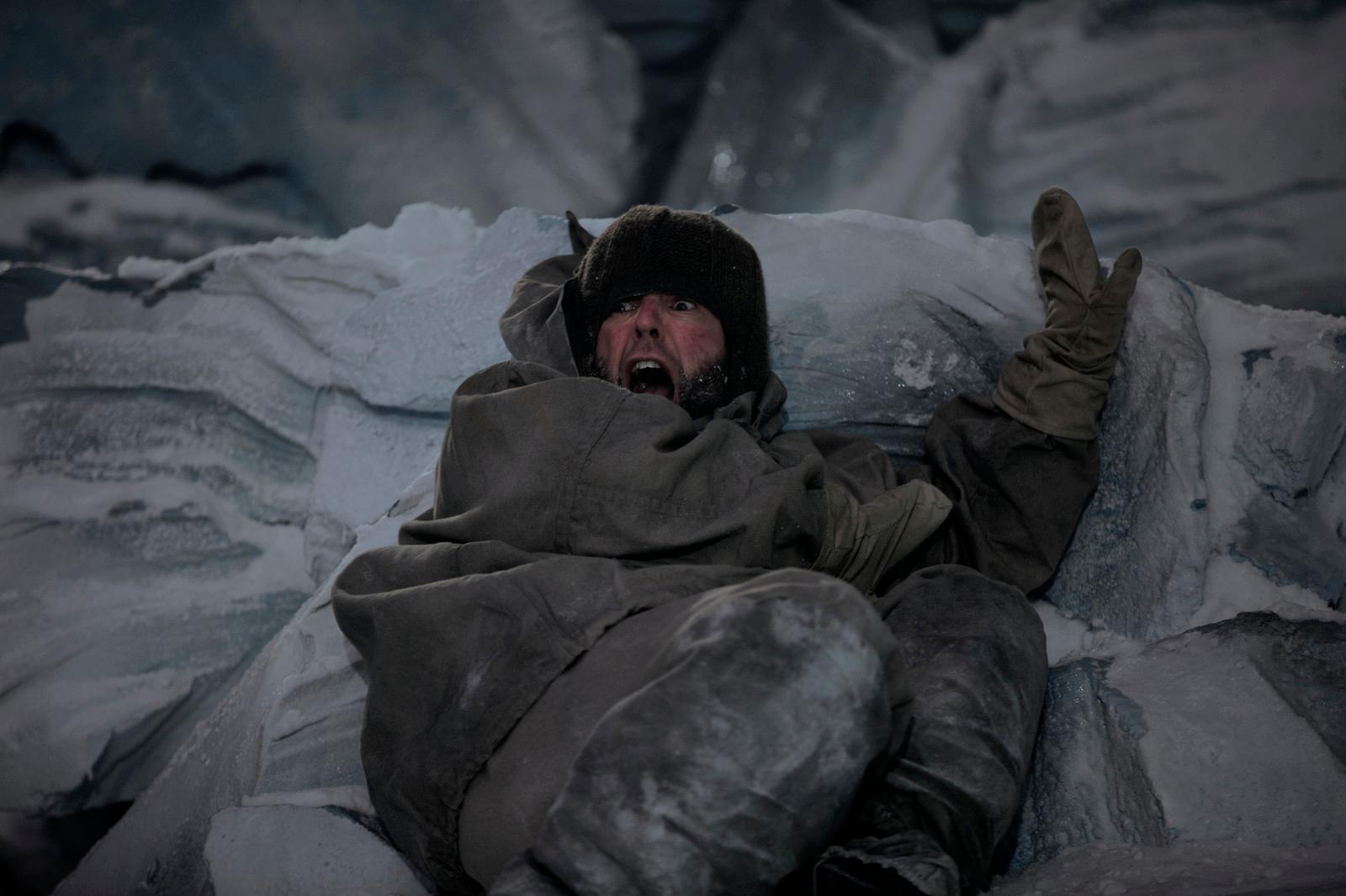 a man laying on top of a pile of ice