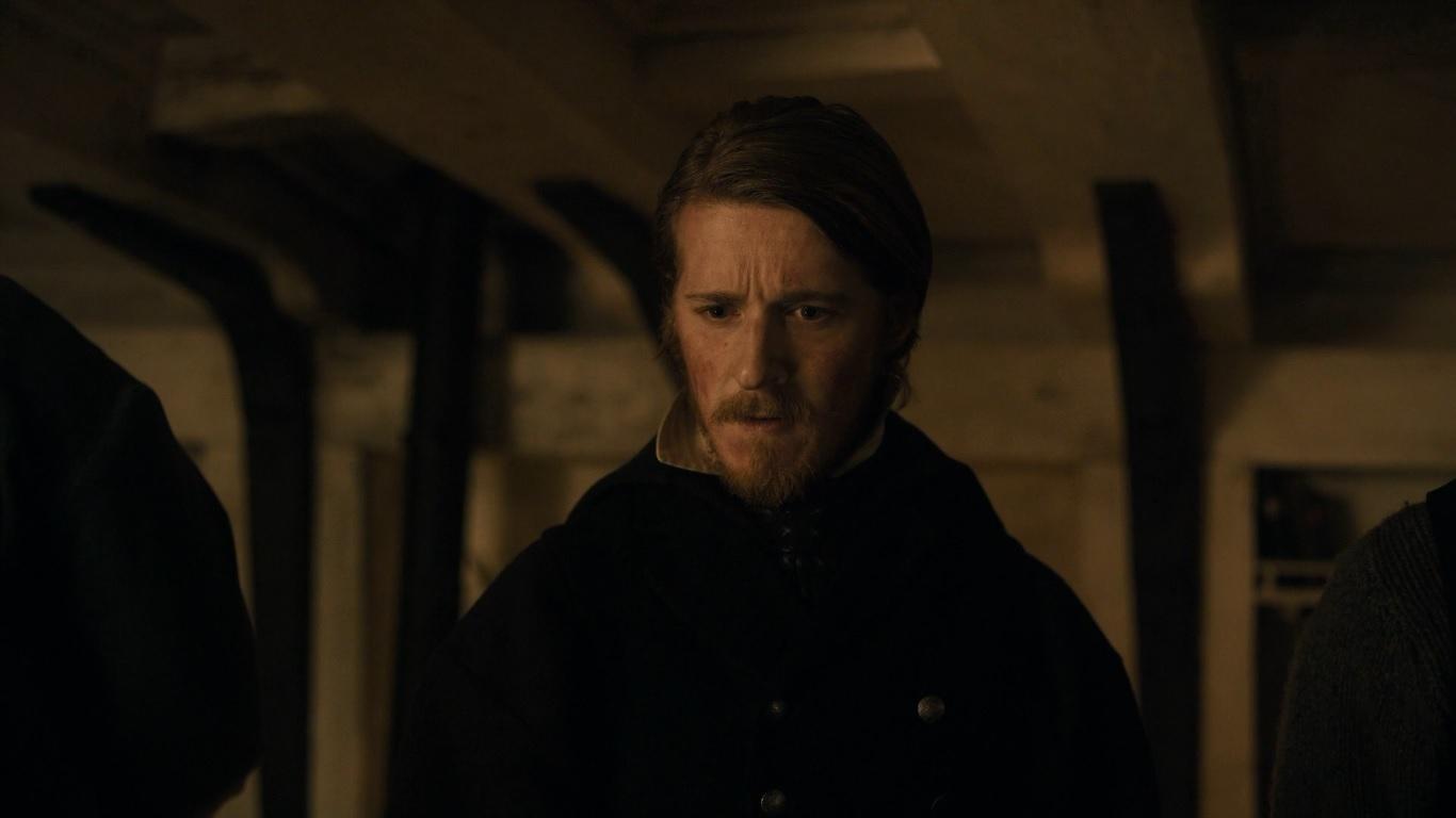 a man with a beard standing in a room