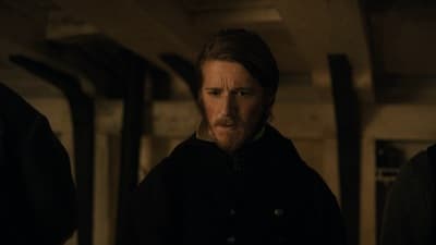 a man with a beard standing in a room