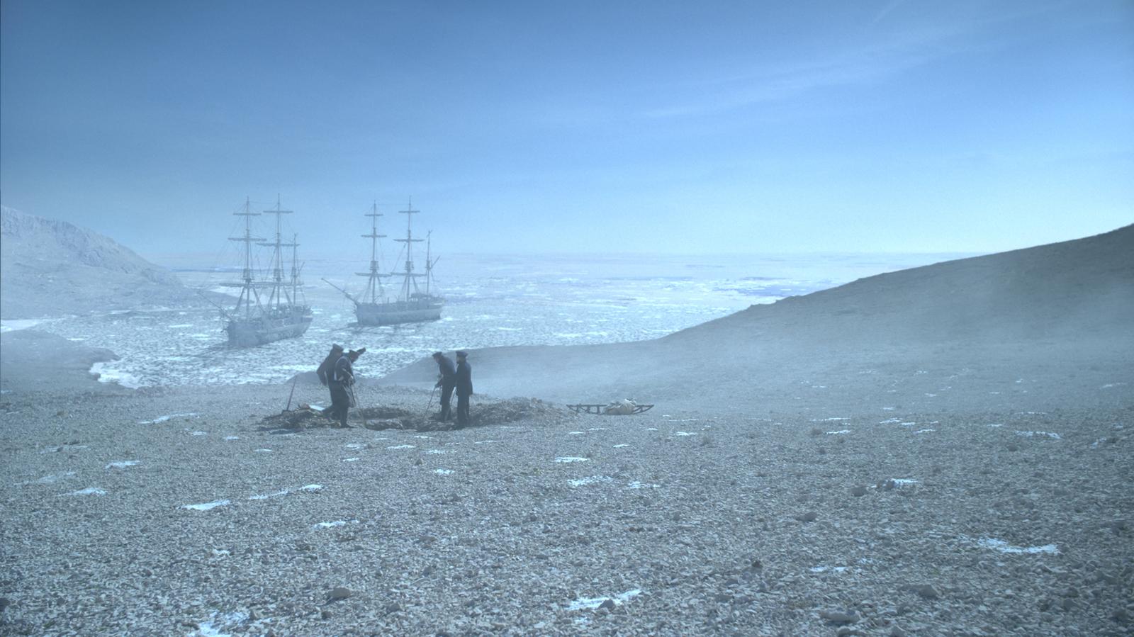 a couple of people standing on top of a snow covered field