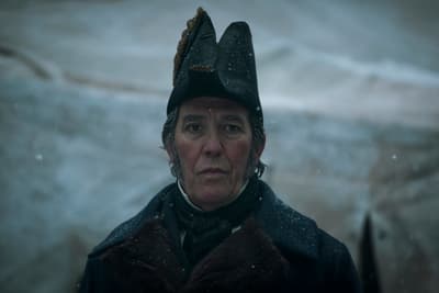 a man wearing a hat and coat in the snow