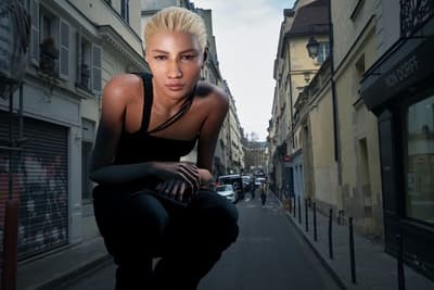a woman is kneeling down on a city street