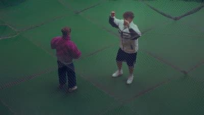two men standing on a tennis court holding a racquet