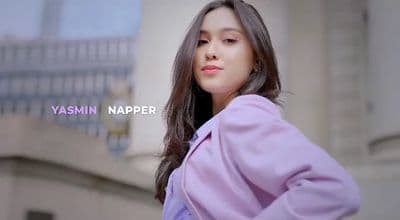 a woman with long dark hair wearing a purple coat