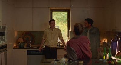 a man standing in a kitchen next to a woman