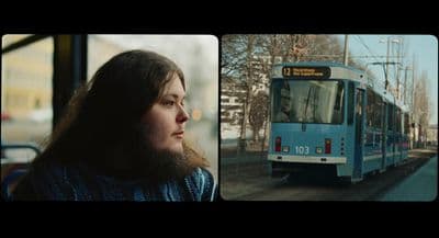 a woman standing in front of a bus on a city street
