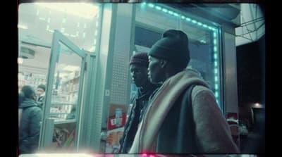 a couple of men standing in front of a store