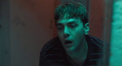 a young man making a face while looking at his cell phone