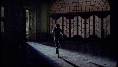 a person standing in a dark room with a window