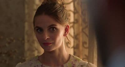 a woman in a dress looking at the camera