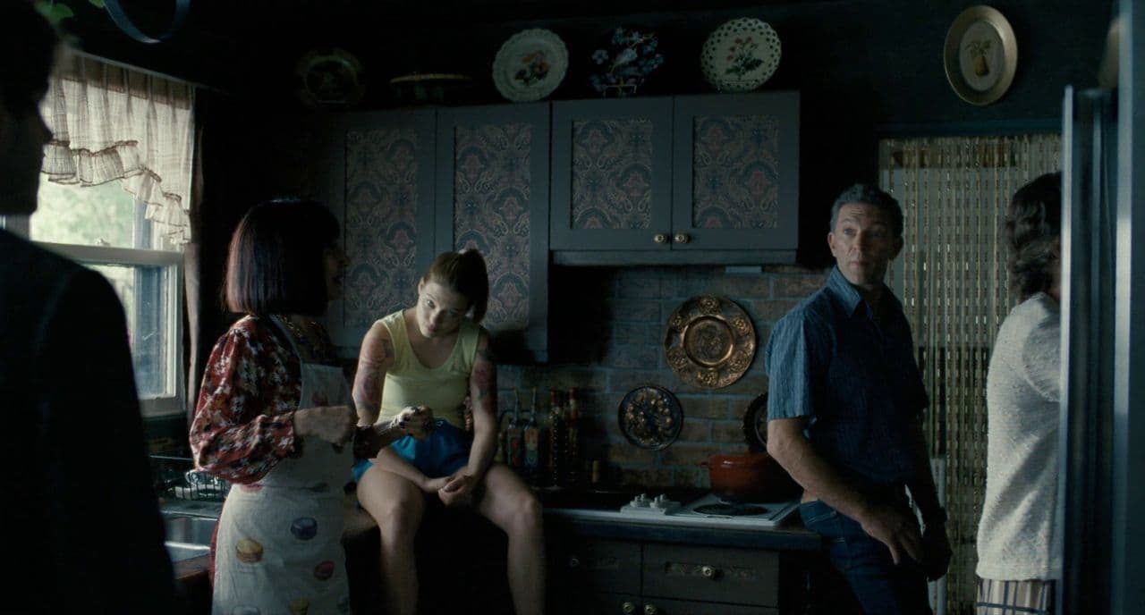 a group of people standing around a kitchen