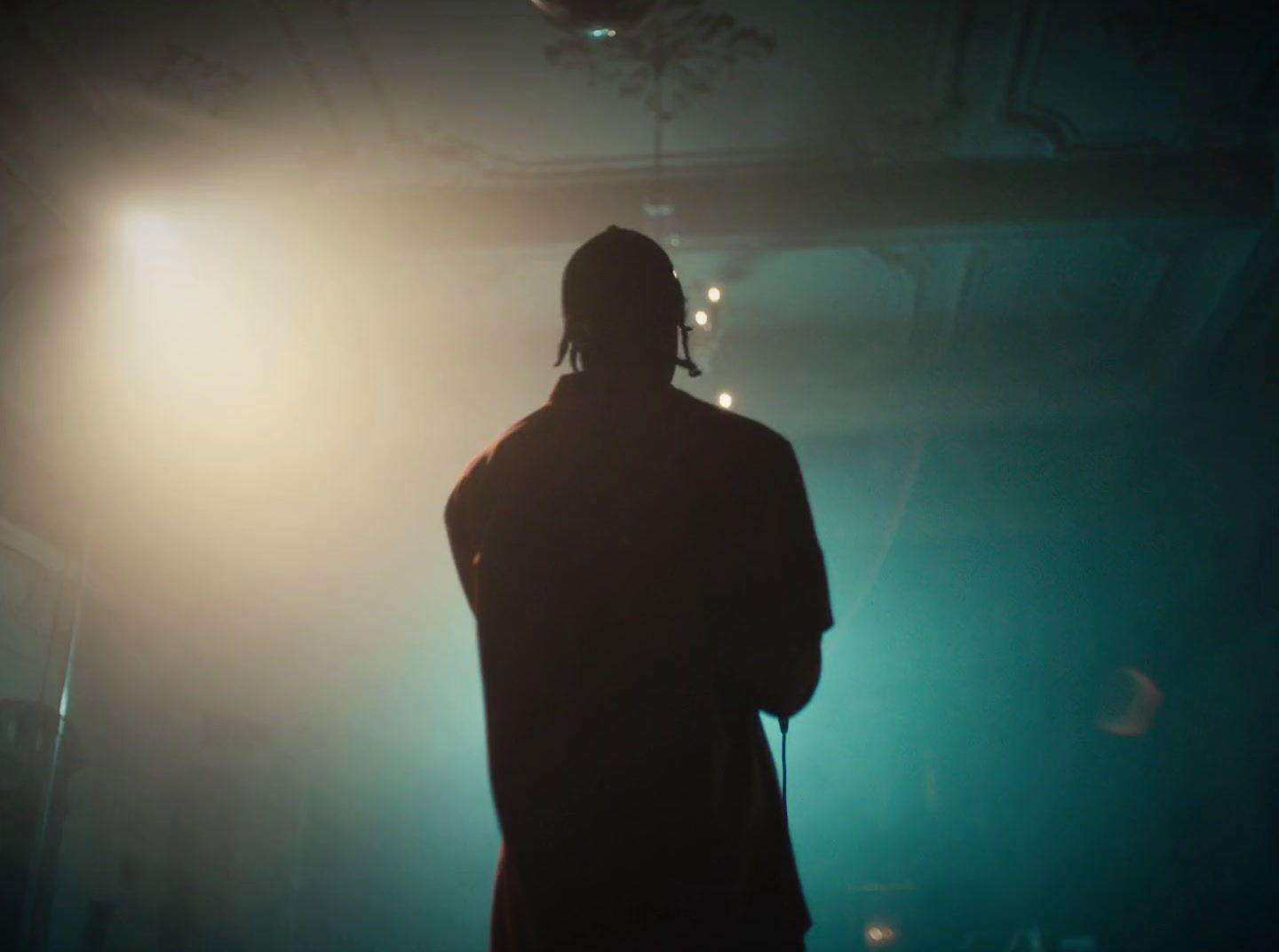 a person standing in front of a light in a dark room
