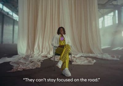 a woman sitting on a chair in front of a curtain