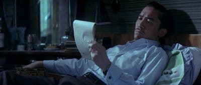a man sitting in a chair reading a paper