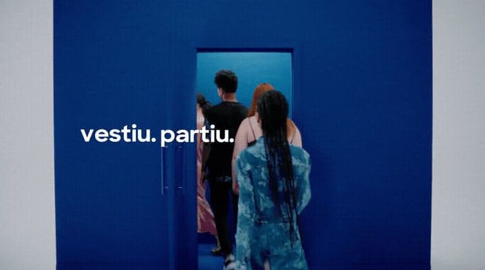 a man and a woman standing in front of a blue wall