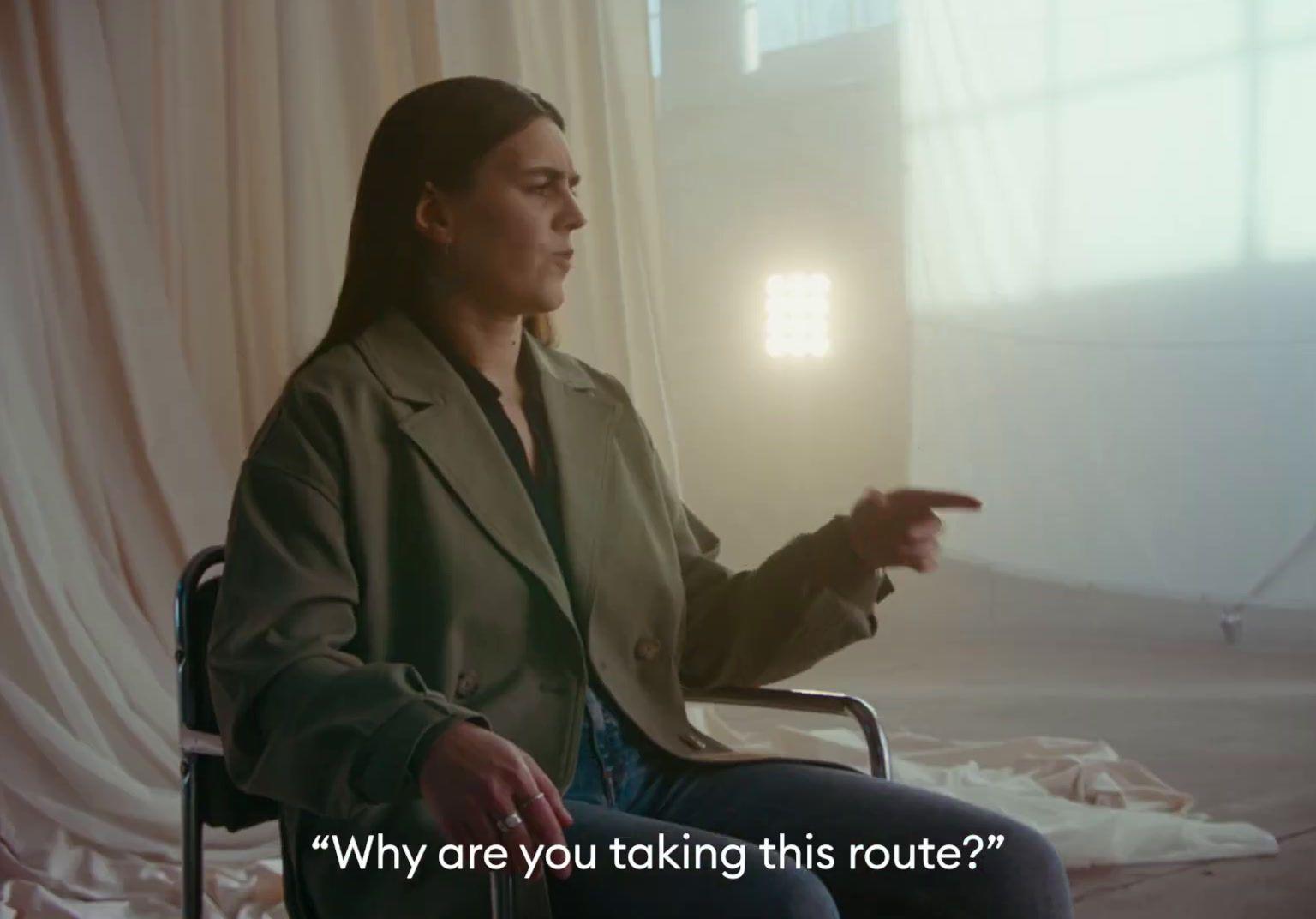 a woman sitting in a chair pointing at something