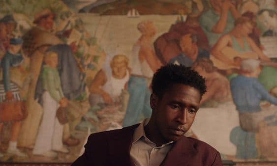 a man is sitting in front of a painting