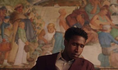 a man is sitting in front of a painting