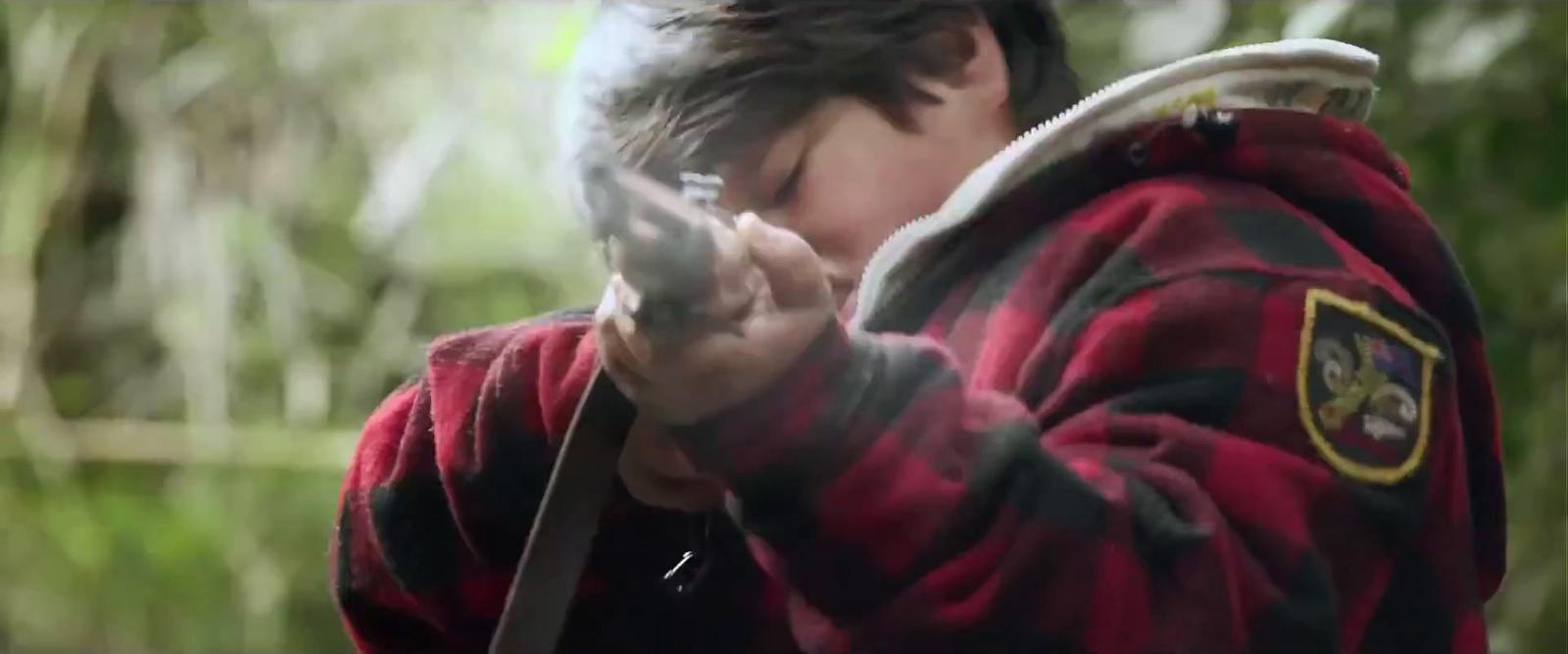 a boy in a red and black jacket holding a cell phone