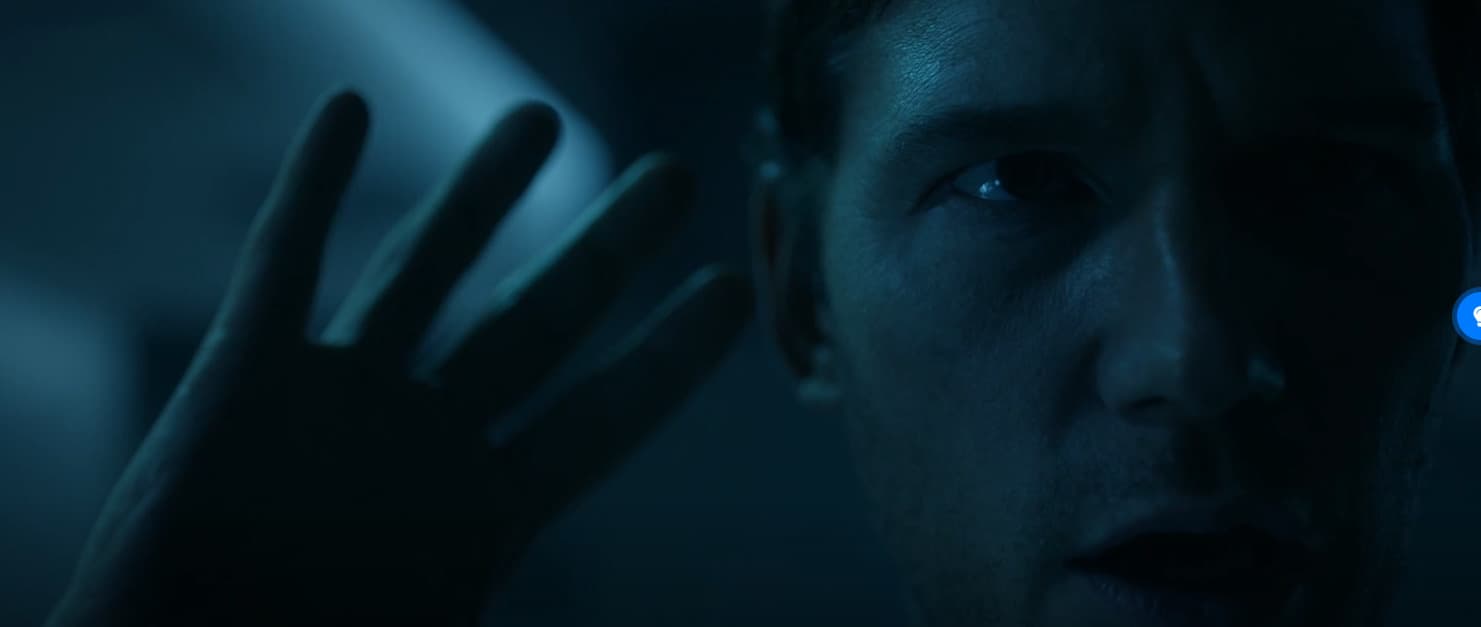 a man holding his hand up to his face