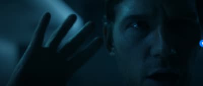 a man holding his hand up to his face
