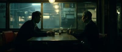 two men sitting at a table in a restaurant