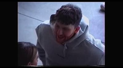 a man in a gray hoodie making a face