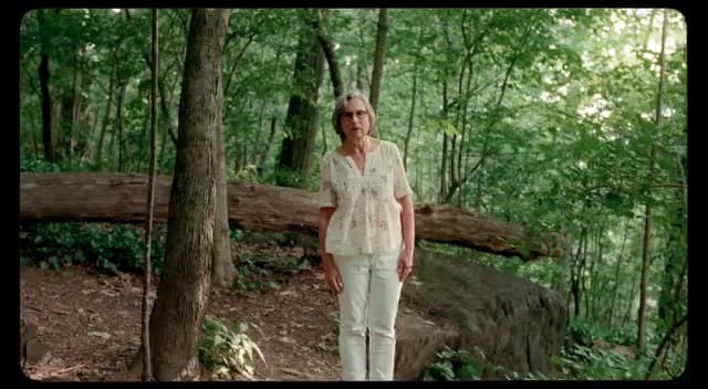 a woman standing in the middle of a forest